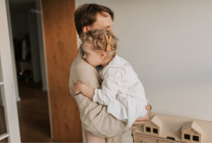 Image of a man holding his infant daughter to depict Father's day