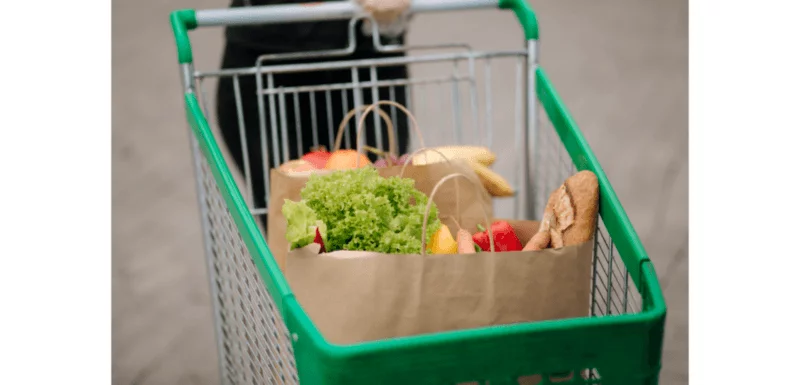 Shopping trolley containing bags of fruit and vegetables